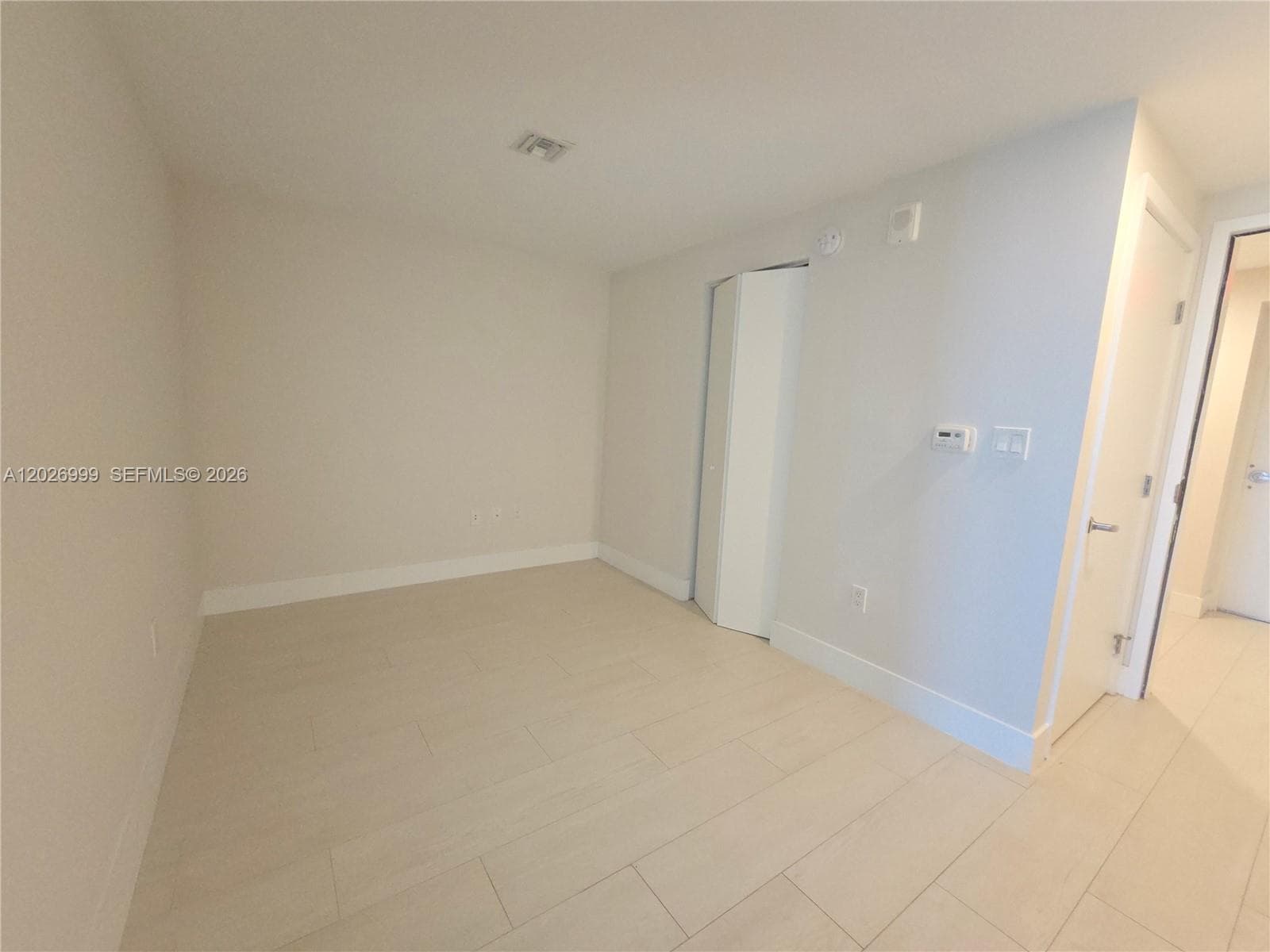 Well-proportioned 2nd bedroom with a large window offering natural light and partial skyline views. Clean finishes and neutral tones create a flexible, modern space.