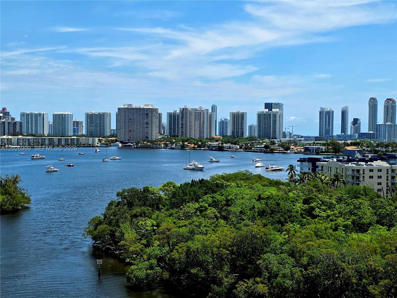 Elevated view showcasing the waterway, boats, lush greenery, and nearby high-rise skyline. This outlook highlights the residence’s connection to the surrounding waterfront setting.
