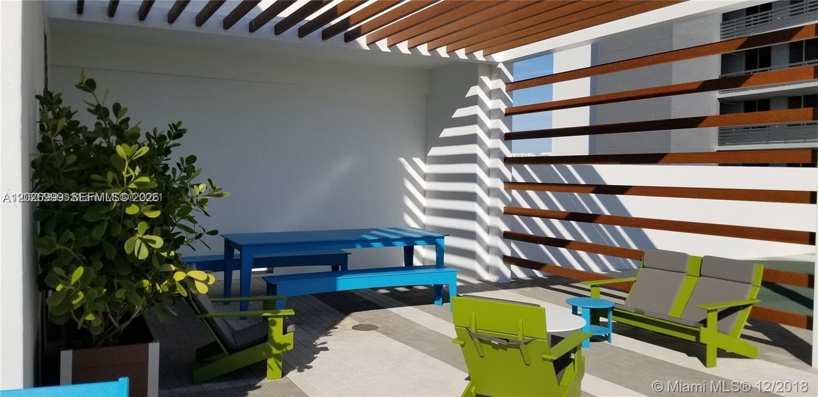 The outdoor sports court offers a versatile setting for tennis and other recreational play, with open sky and surrounding tower views.