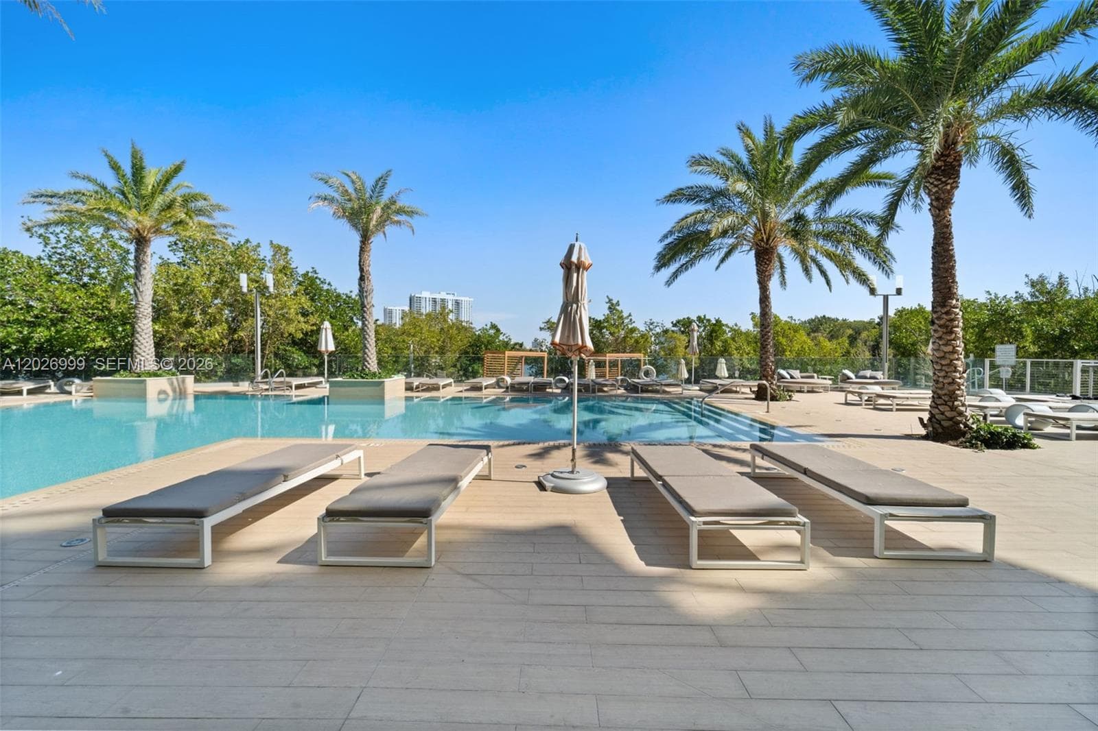A serene outdoor seating area overlooks lush greenery and the waterway, creating a peaceful spot to unwind.