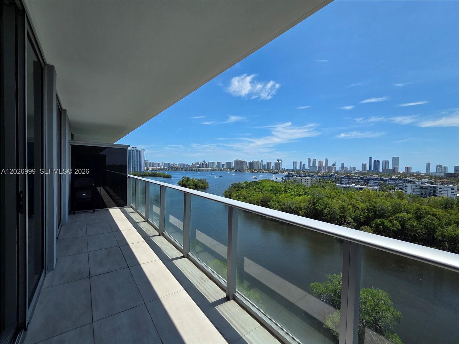Expansive skyline views rise above the treetops, offering a dramatic urban backdrop. The combination of greenery, water, and city architecture adds visual depth.