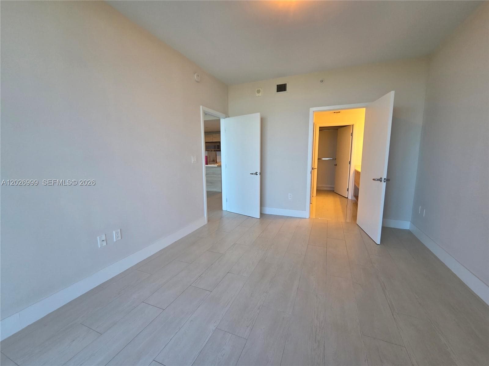This spacious walk-in closet includes custom built-ins with hanging space, open shelving, and drawer storage for everyday organization.