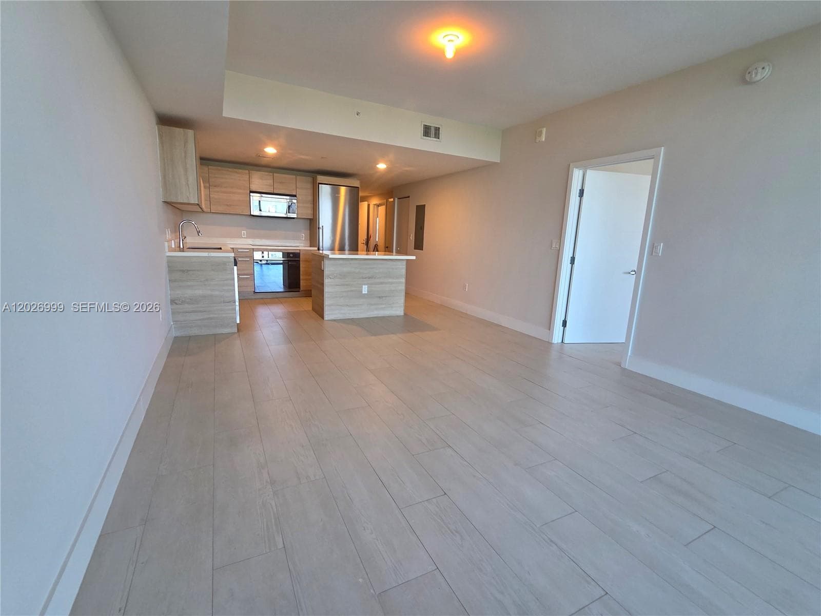 The kitchen features sleek cabinetry, quartz-style countertops, stainless steel appliances, and a streamlined layout for everyday functionality.