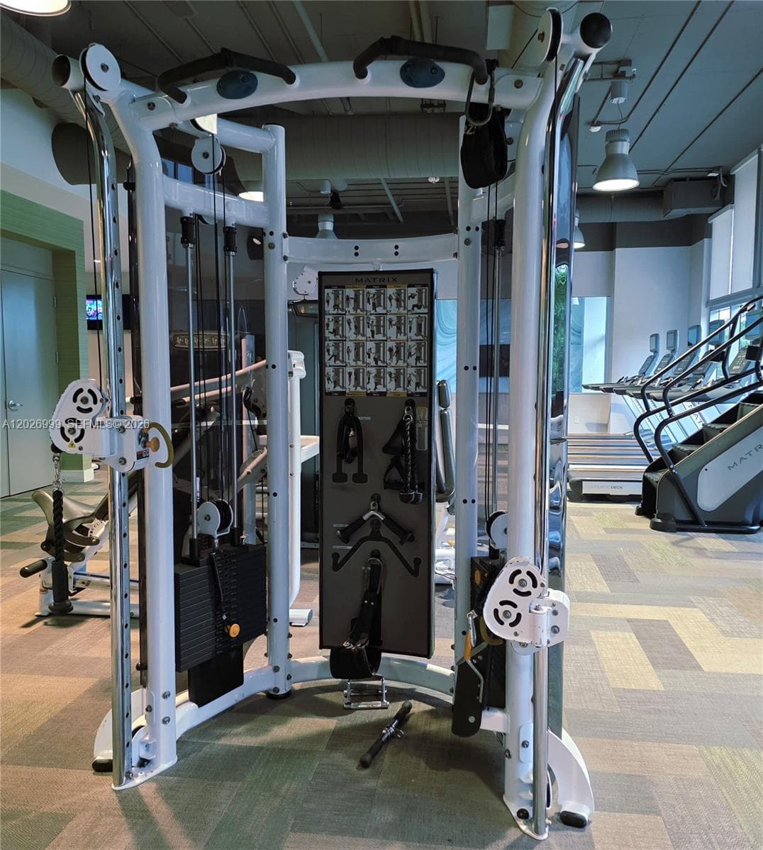 The children’s playroom features a climbing wall, activity tables, lounge seating, and floor-to-ceiling windows. This bright amenity space offers a dedicated area for play and recreation.