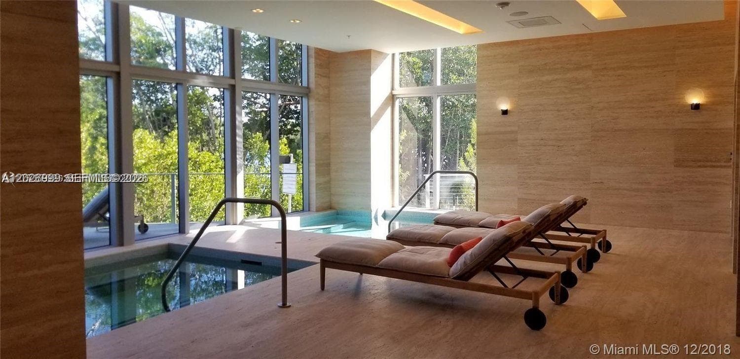 A stylish resident lounge includes a pool table, built-in shelving, comfortable seating, and modern lighting. The space is designed for relaxed gatherings and everyday enjoyment.