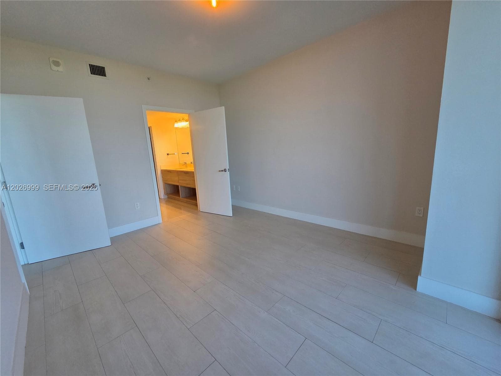 The entry foyer leads into the residence with light flooring, crisp white doors, and a clear sightline toward the living area.