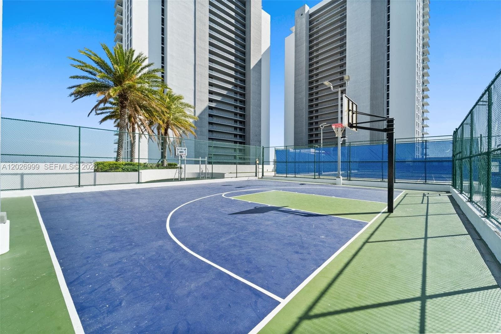 The building’s waterfront pool area and marina-side setting are framed by tropical landscaping and open bay views.