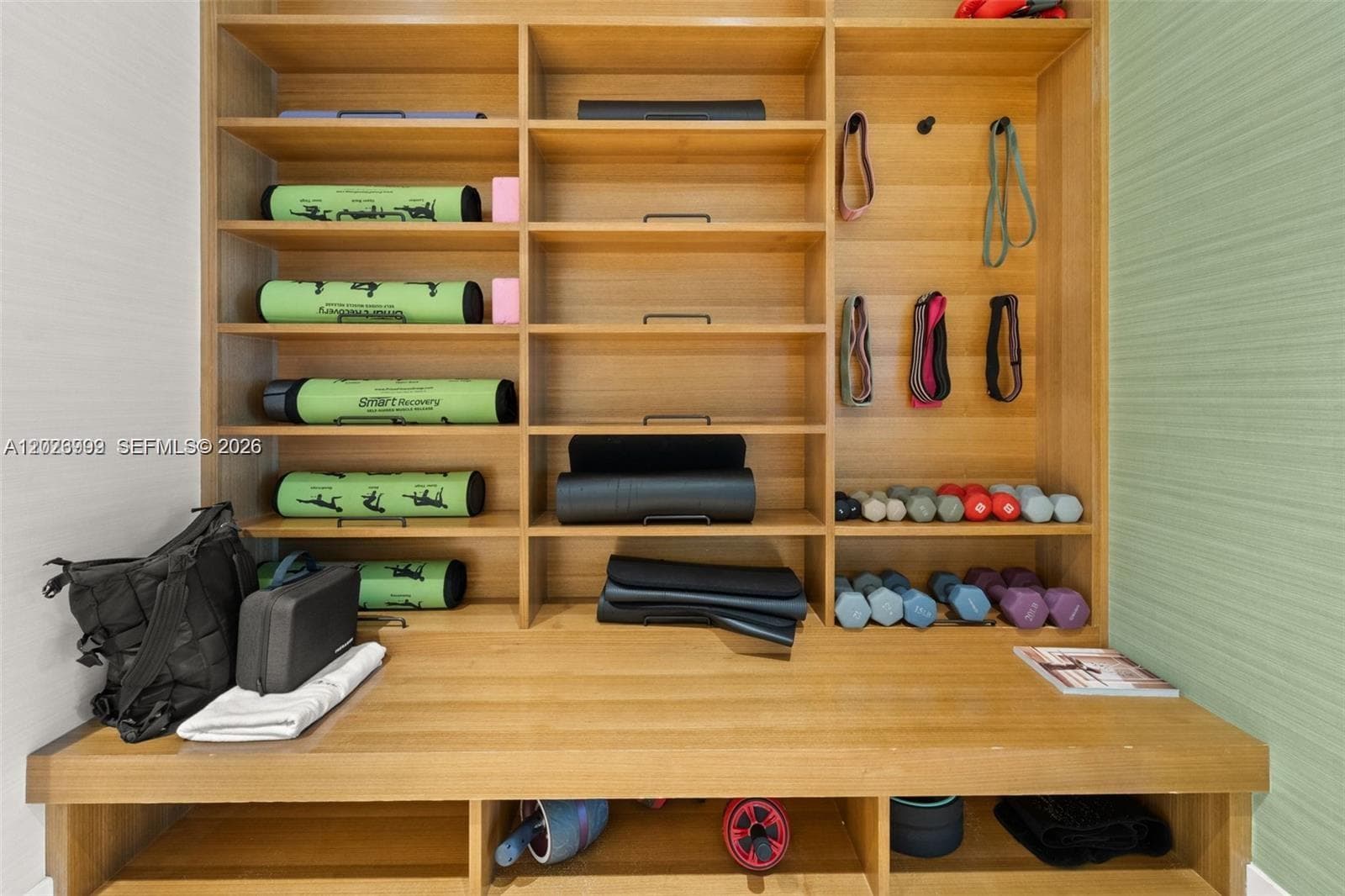 The fitness center includes strength-training equipment, free weights, and large windows overlooking the outdoor areas. The amenity space supports an active lifestyle within the building.
