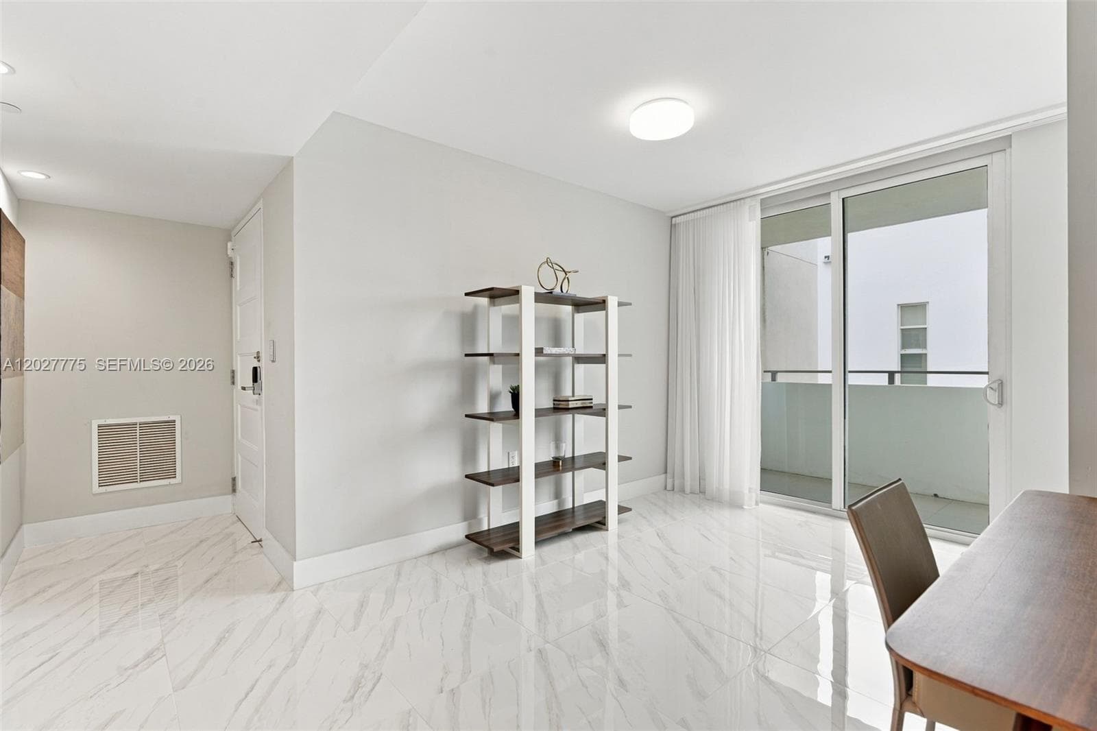 Polished tile flooring, white walls, and a sliding glass door to a private balcony