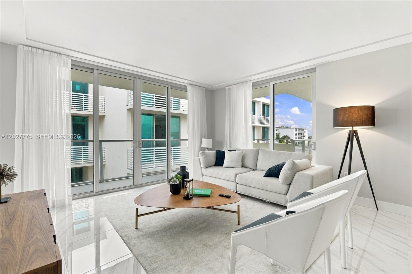 Expansive floor-to-ceiling sliding glass doors, white tile flooring, recessed ceiling lighting, and a modern ceiling design