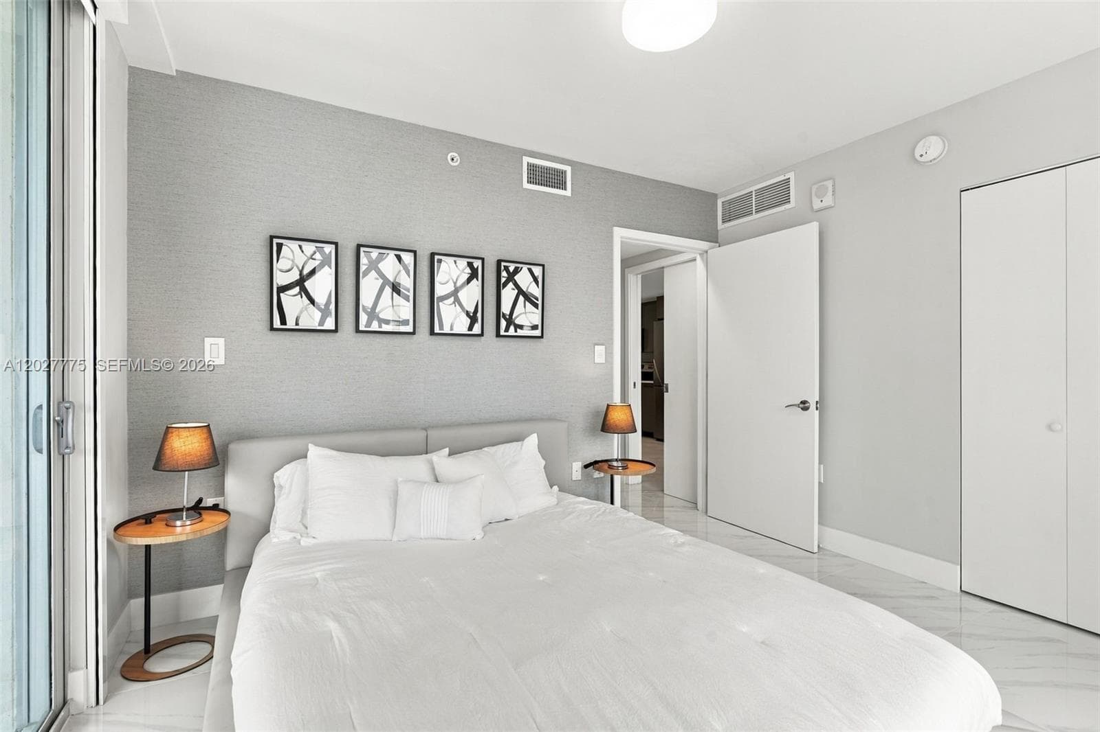 Expansive sliding glass doors, textured accent wall, polished tile flooring, recessed lighting, and a neutral color palette