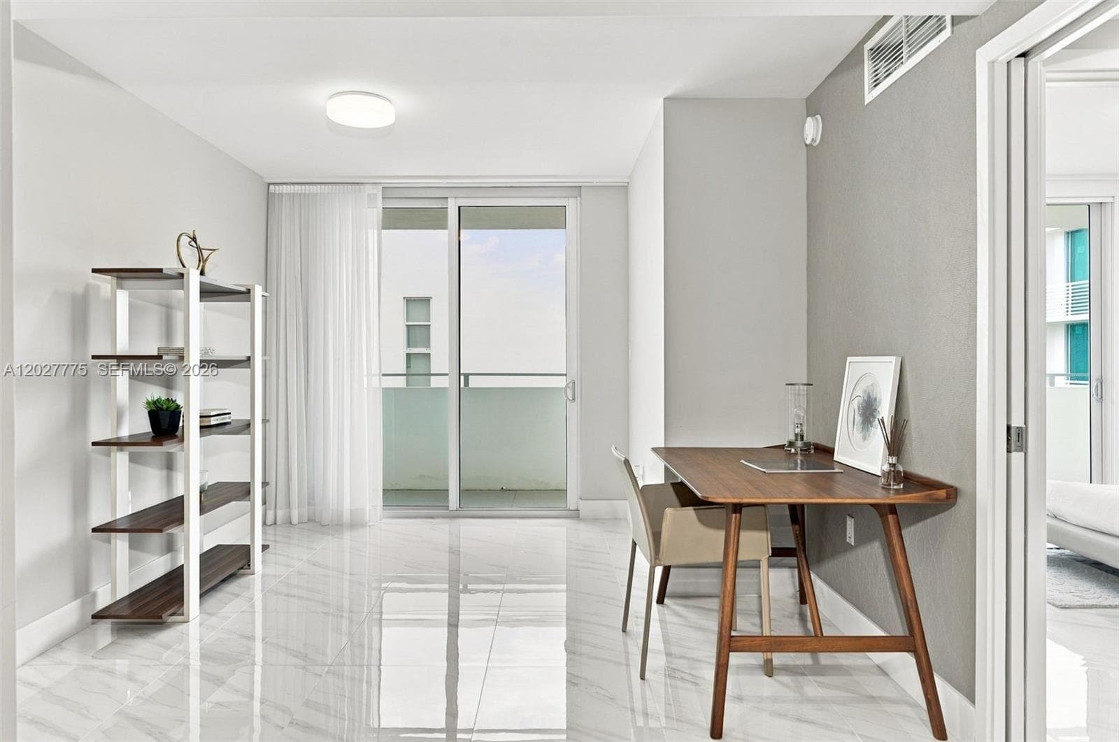 Polished tile flooring throughout, sliding glass doors to a balcony, and a recessed ceiling light fixture