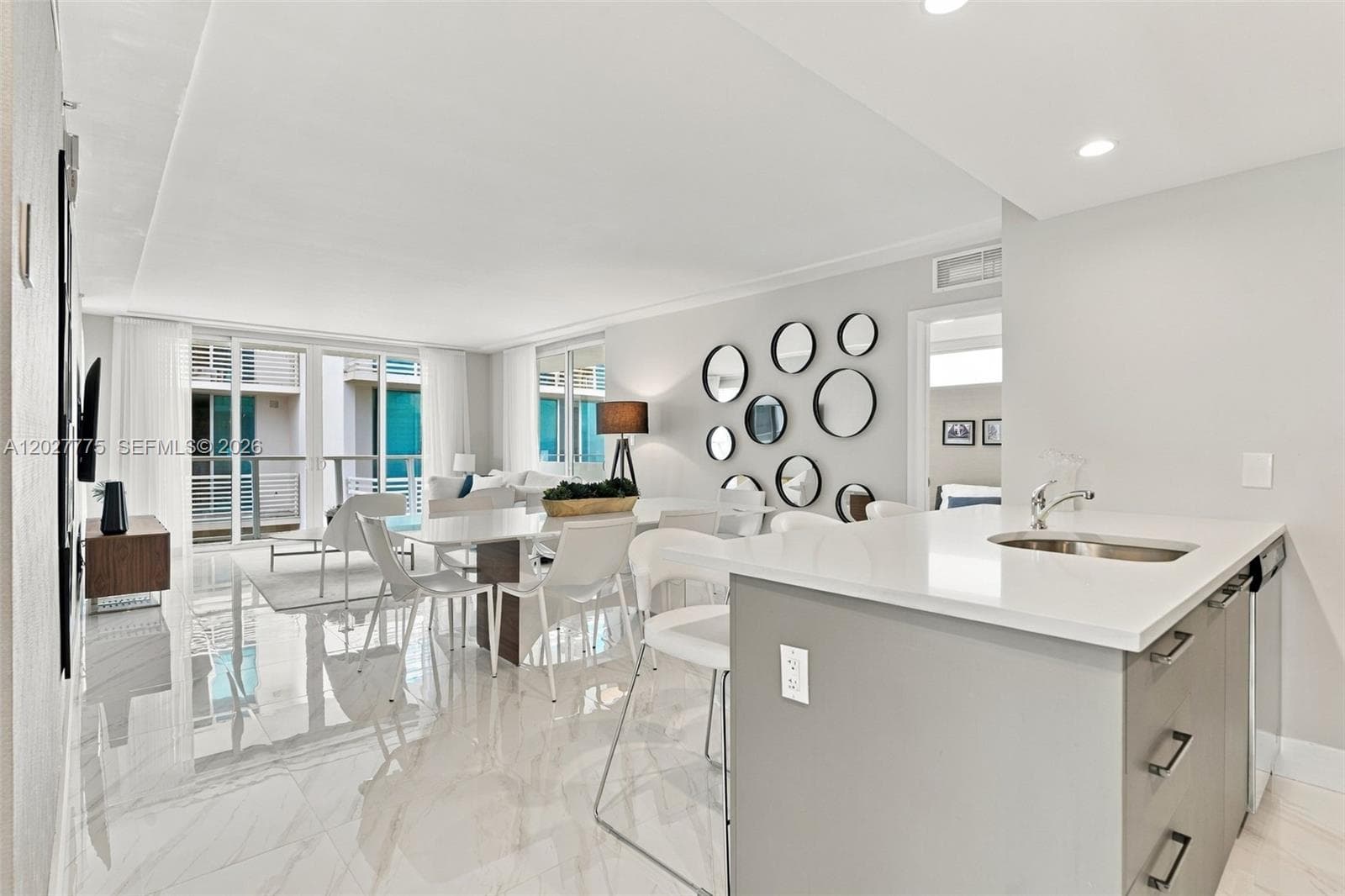 Open-concept living space featuring high ceilings, recessed lighting, expansive glass sliding doors, and polished tile flooring