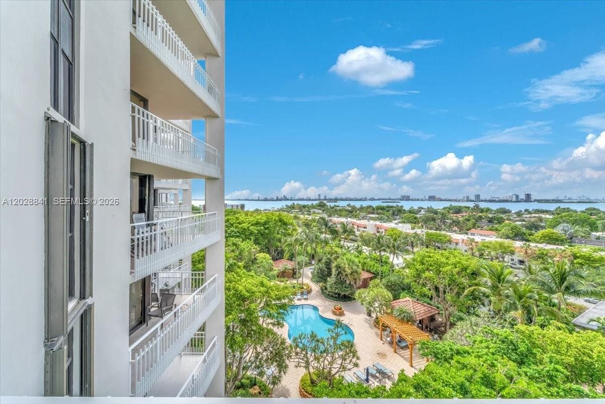 Experience the breathtaking view from the pool deck, where lush greenery surrounds you and the vibrant city skyline awaits in the distance.