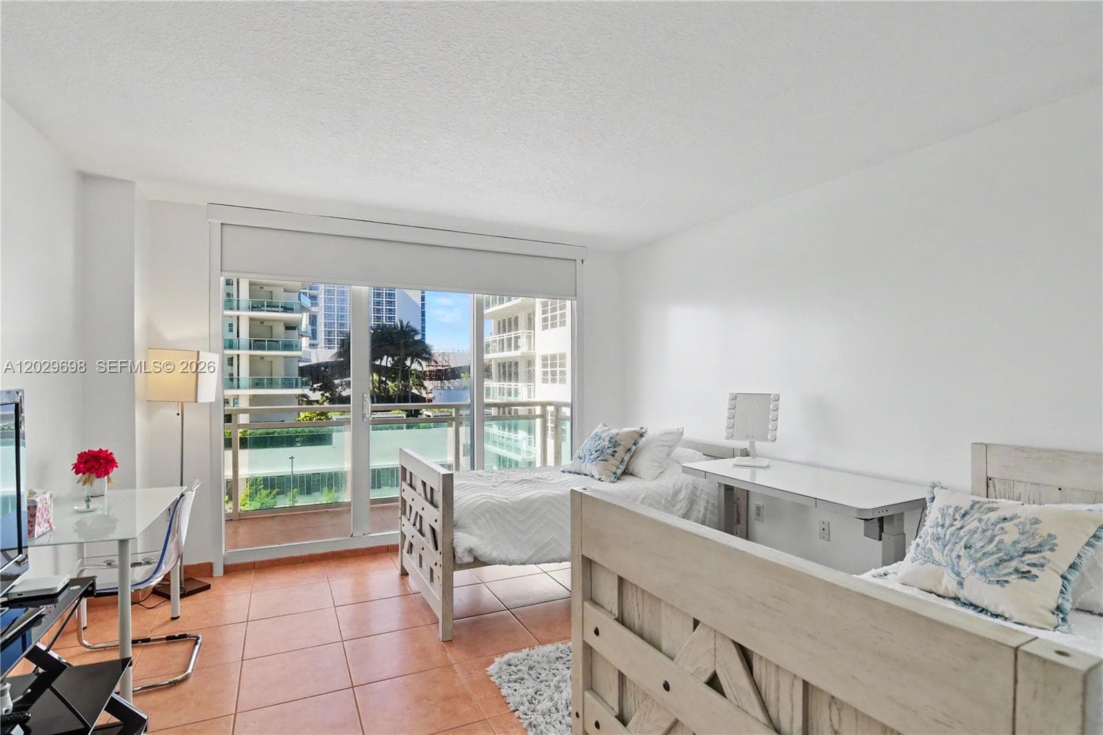 Primary bedroom with floor to ceiling impact resistant doors and access to the balcony.