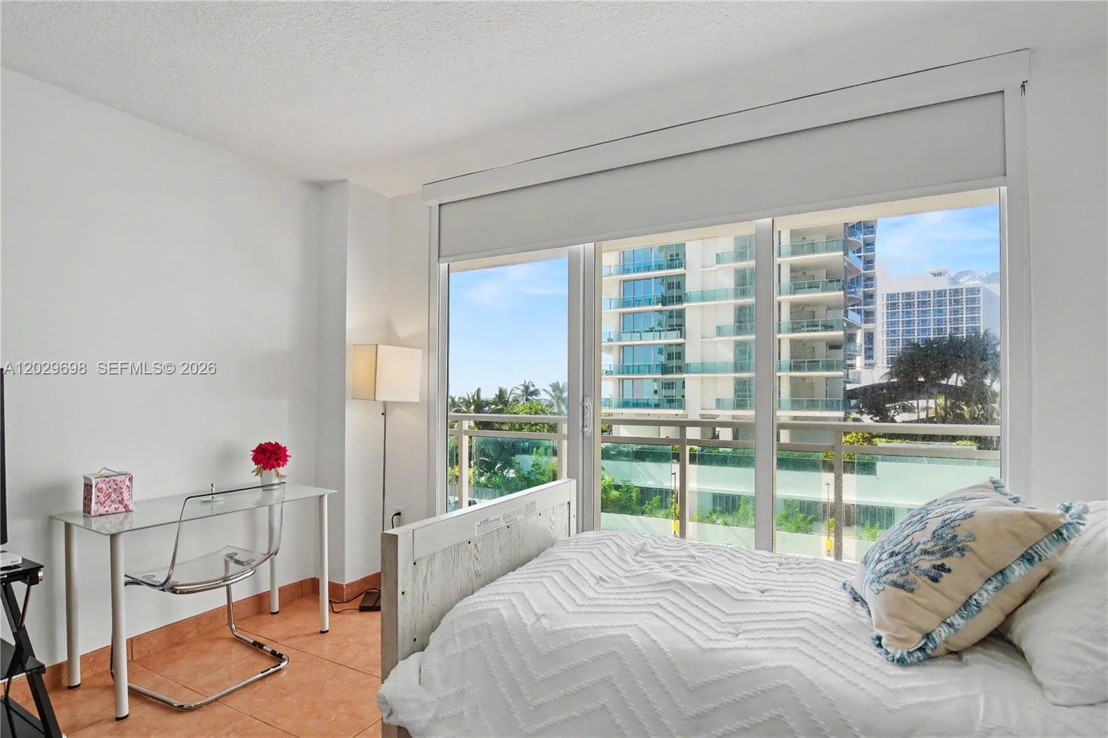 Primary bedroom with floor to ceiling impact resistant doors and access to the balcony.