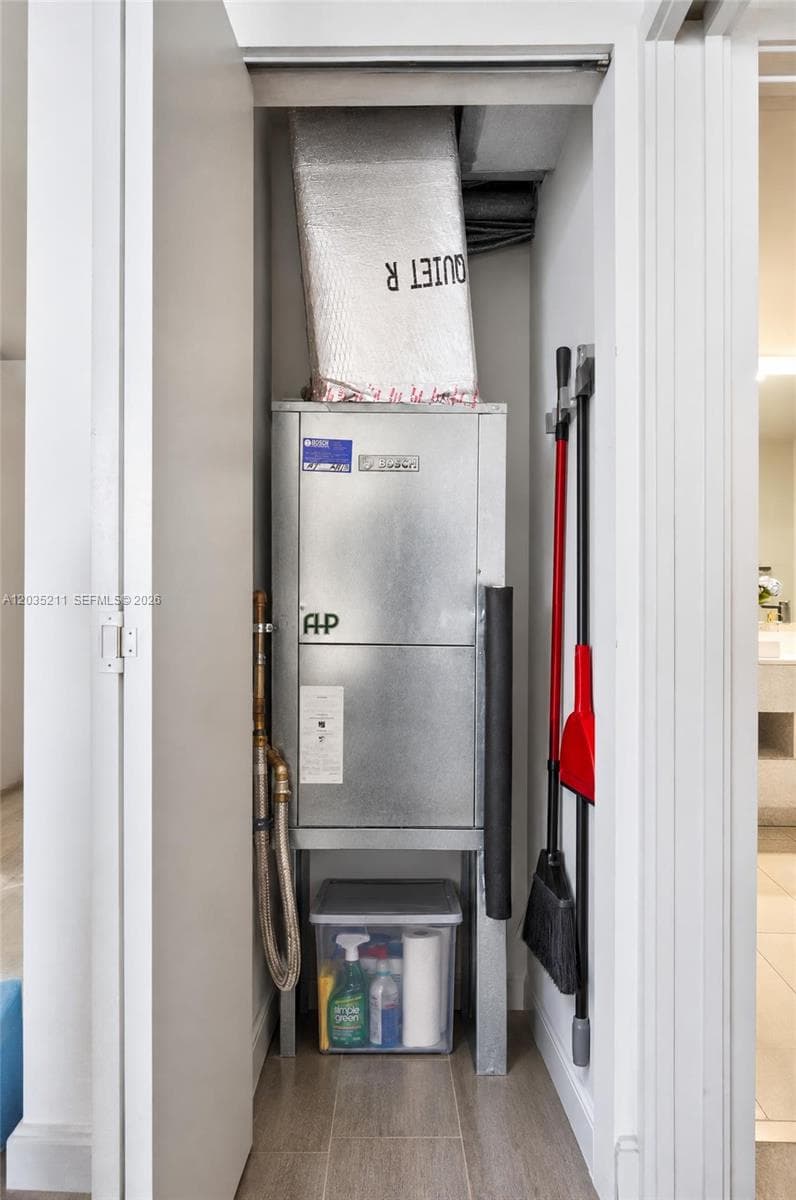 Utility closet featuring a dedicated HVAC air handler unit and tiled flooring