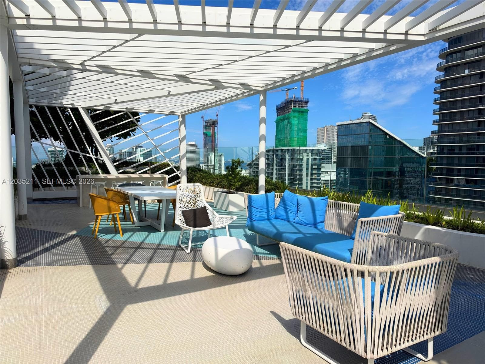 Outdoor terrace featuring a white pergola, built-in stone serving counter, and glass balustrades
