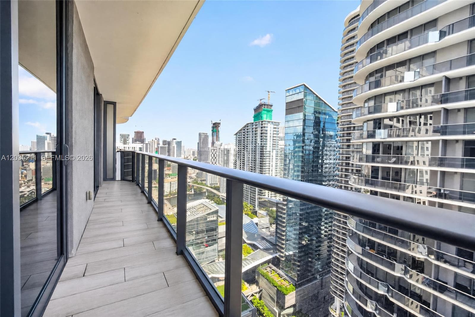 Private balcony featuring tile flooring and a dark metal railing with glass paneling