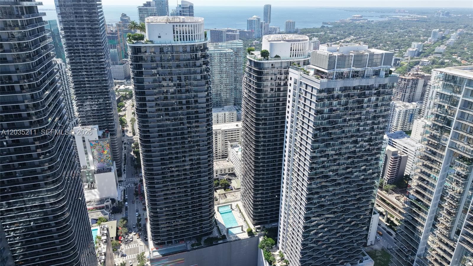 High-rise residential towers featuring glass-paneled balconies, rooftop landscaping, and exterior swimming pools