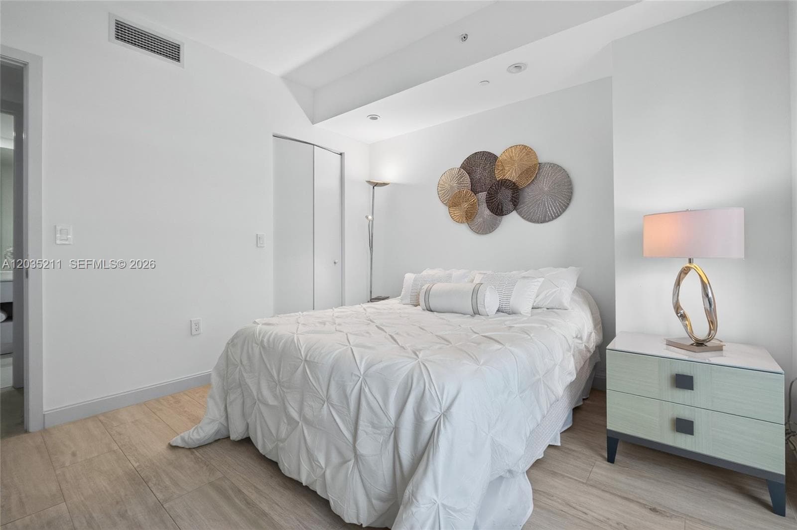 Room with wood-finish flooring, recessed lighting, and built-in closet with sliding doors