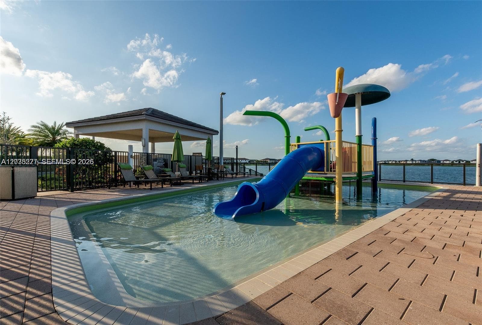 Tranquil lakeside spa nestled beneath a sleek pergola, offering soothing water views and lush privacy landscaping. A stylish paver deck and modern glass railing complete this serene relaxation retreat.