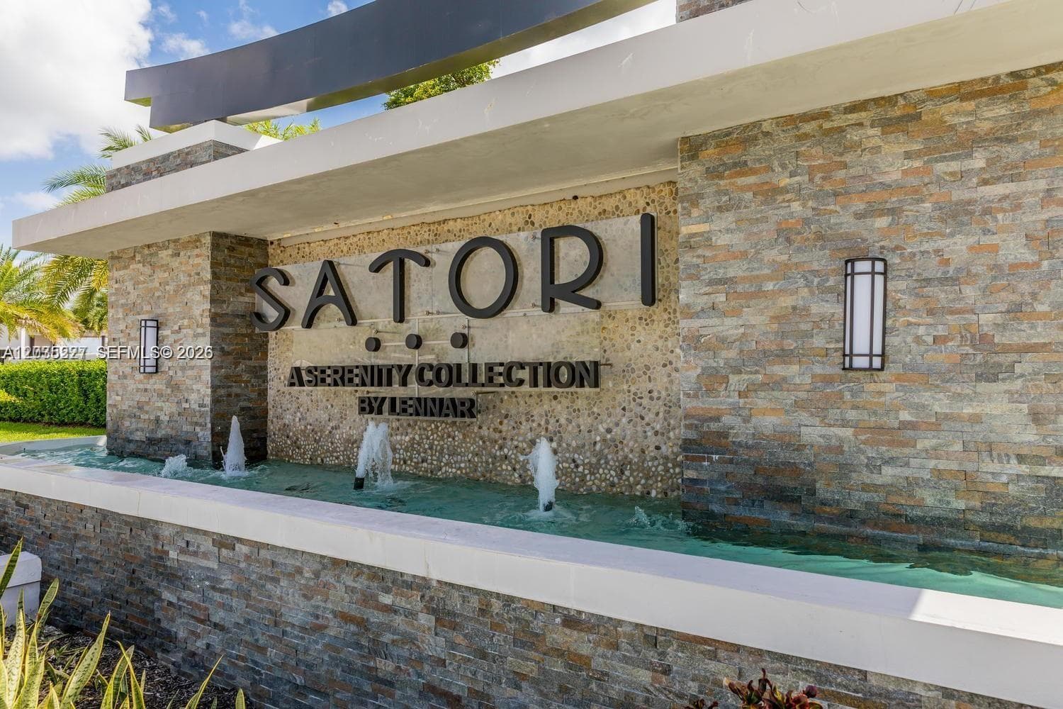 Eye-catching Satori community entrance featuring a stacked-stone monument sign and cascading water fountains. This striking architectural statement sets the tone for the upscale lifestyle awaiting residents inside.