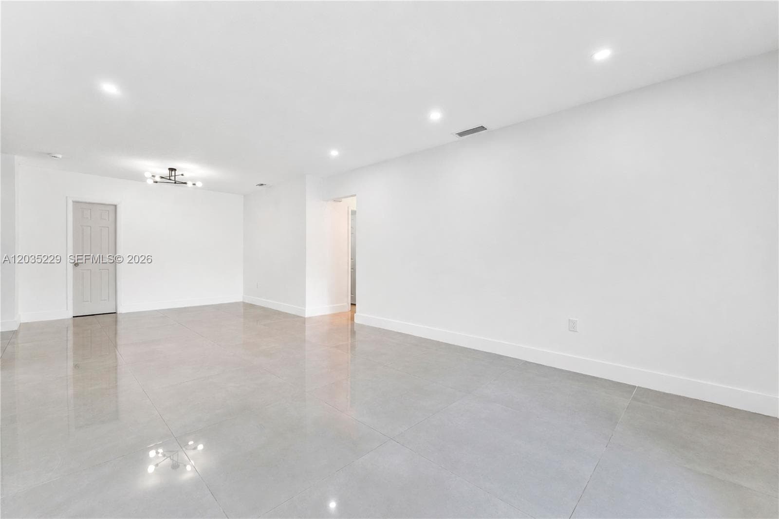 Spacious open-concept living area with recessed lighting.