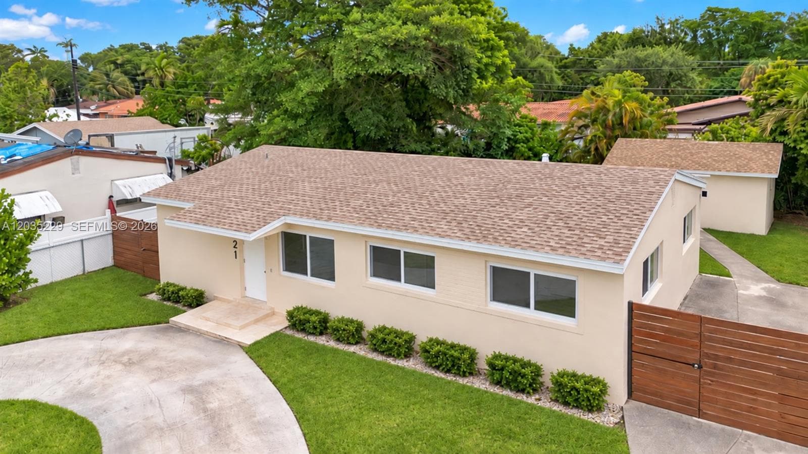 Angled aerial view featuring the new roof, updated exterior, and privacy fencing. AI-edited photograph for marketing purposes.