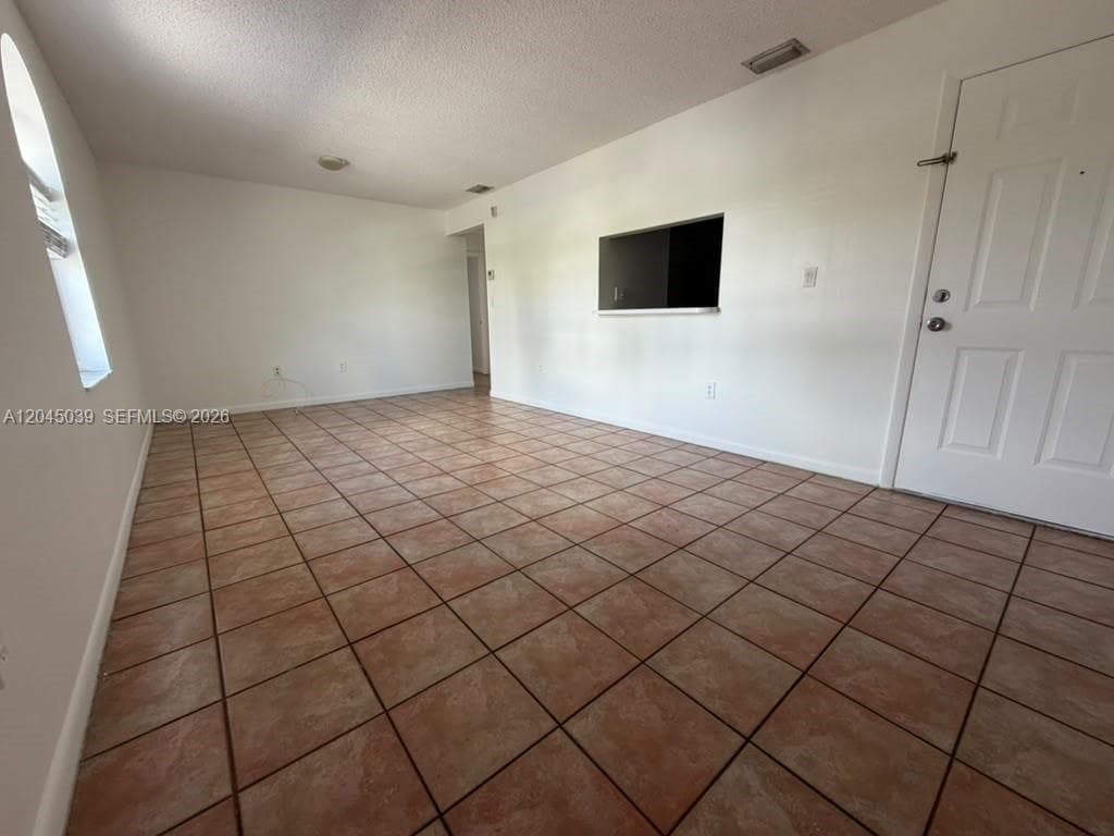 Ceramic tile flooring, arched window, and interior wall pass-through