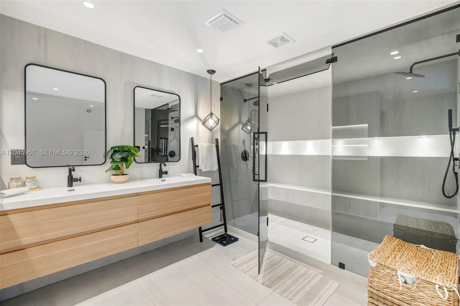 A spa-inspired primary bath featuring floating dual vanities, oversized frameless glass shower, integrated lighting, and a clean, contemporary design palette.