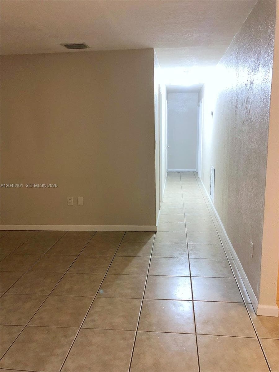 Neutral-toned interior featuring large-format ceramic tile flooring and textured wall surfaces