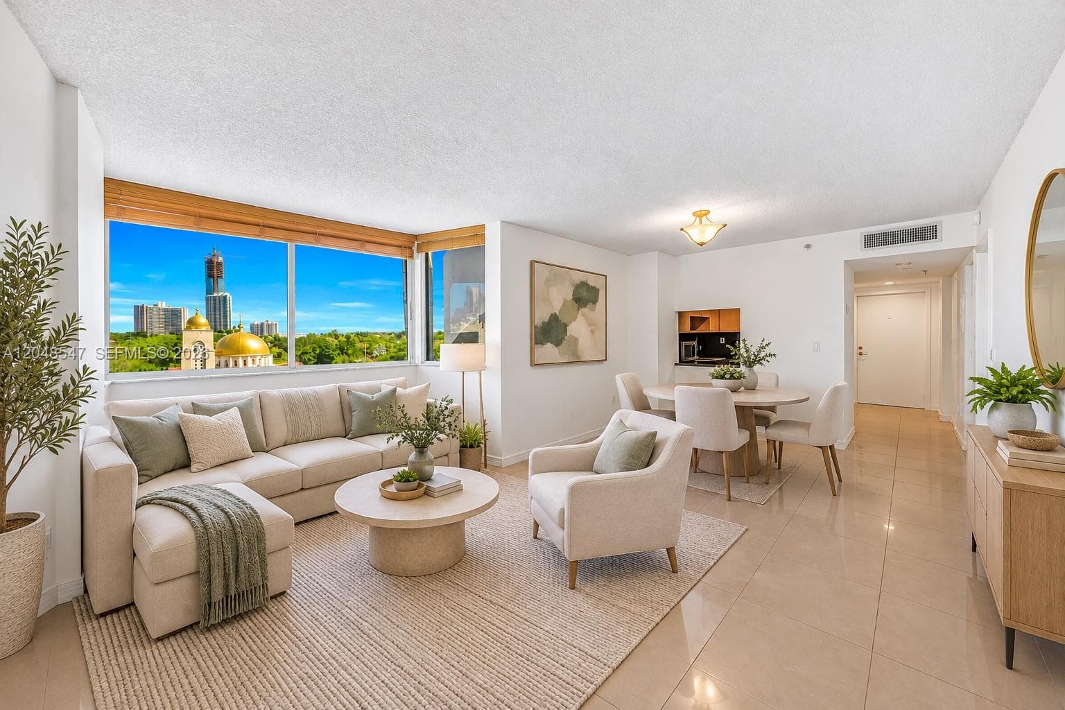 Open-concept living space featuring floor-to-ceiling windows, polished tile flooring, and a built-in kitchen cabinetry unit