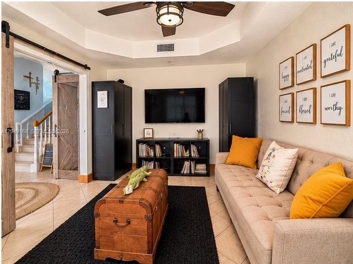 Tray ceiling, sliding barn door with matte black hardware, and tile flooring