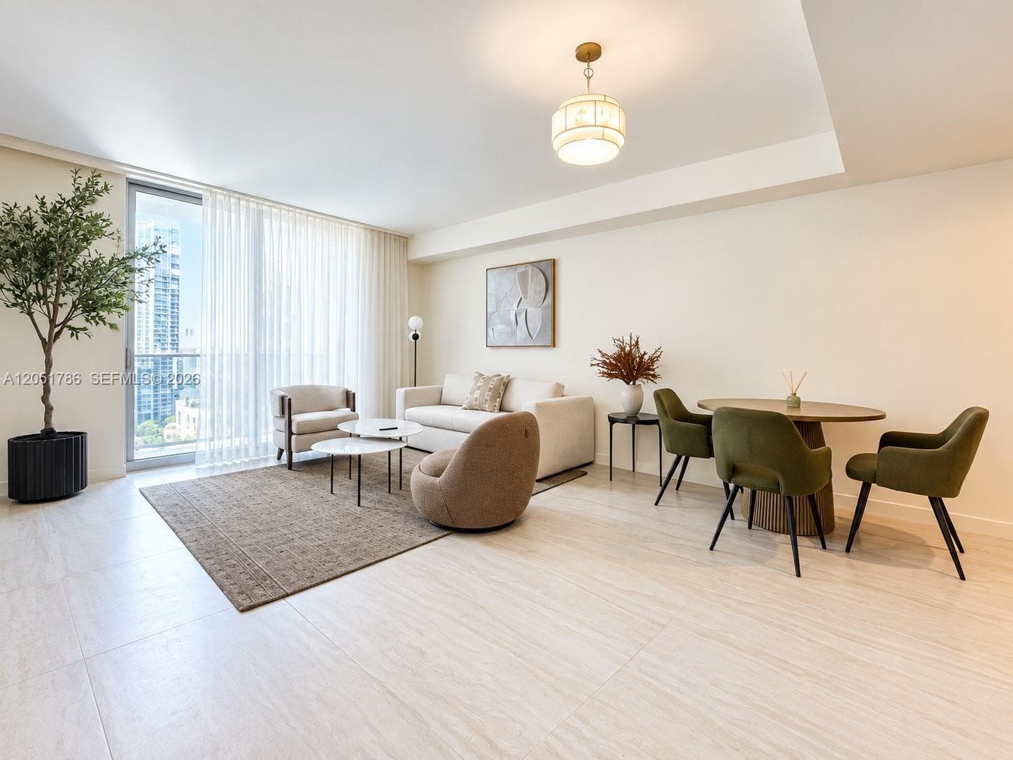 Living area featuring large-format tile flooring, recessed tray ceiling, floor-to-ceiling glass sliding door, and a circular drum pendant light
