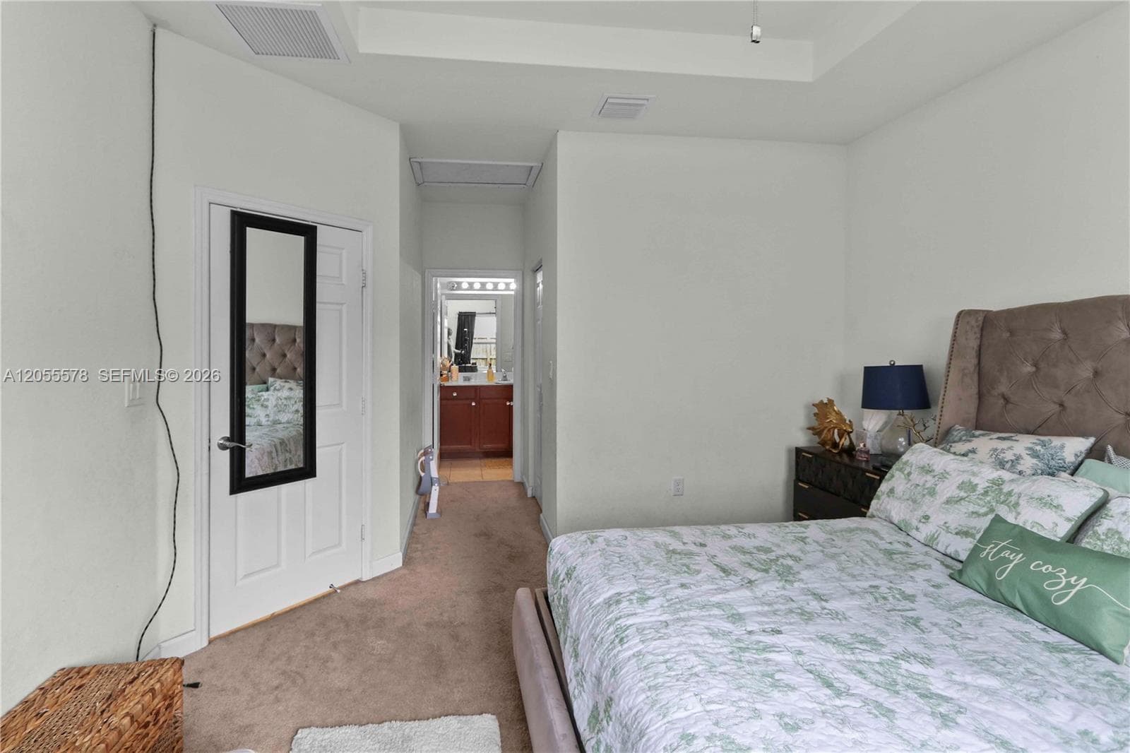 Thoughtfully designed, this view of the primary bedroom highlights the seamless transition to the ensuite bathroom, emphasizing the private, suite-style convenience of this inviting master retreat.