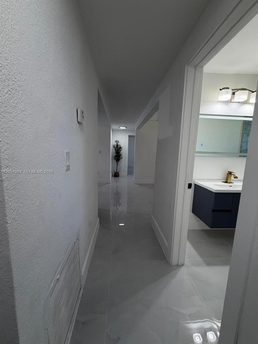 Polished large-format tile flooring extending through the hallway