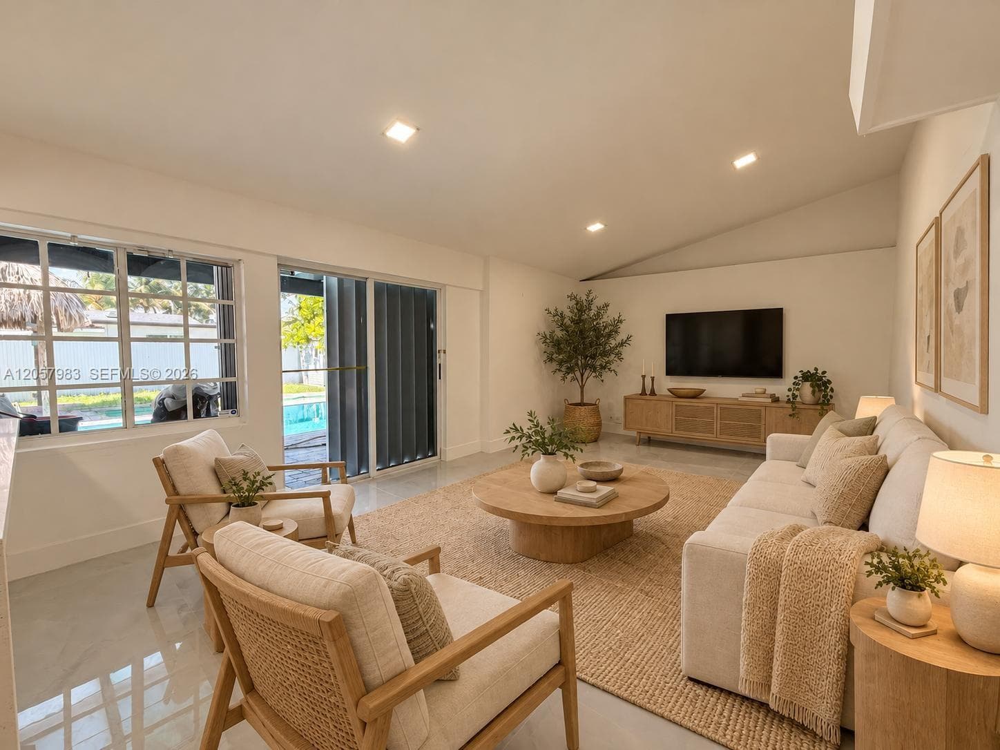 Spacious living area featuring a vaulted ceiling and recessed lighting