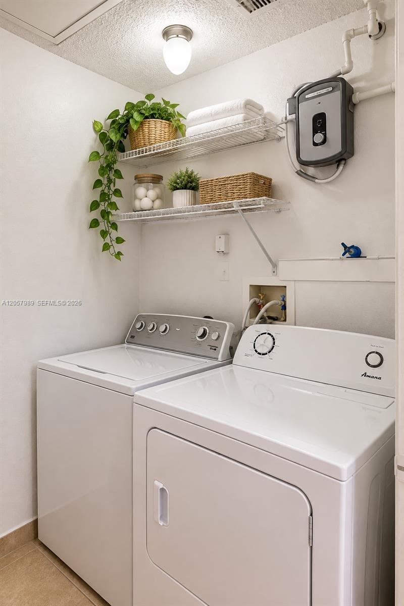 Laundry area featuring two levels of wall-mounted wire shelving, a tankless electric water heater, and flush-mount lighting