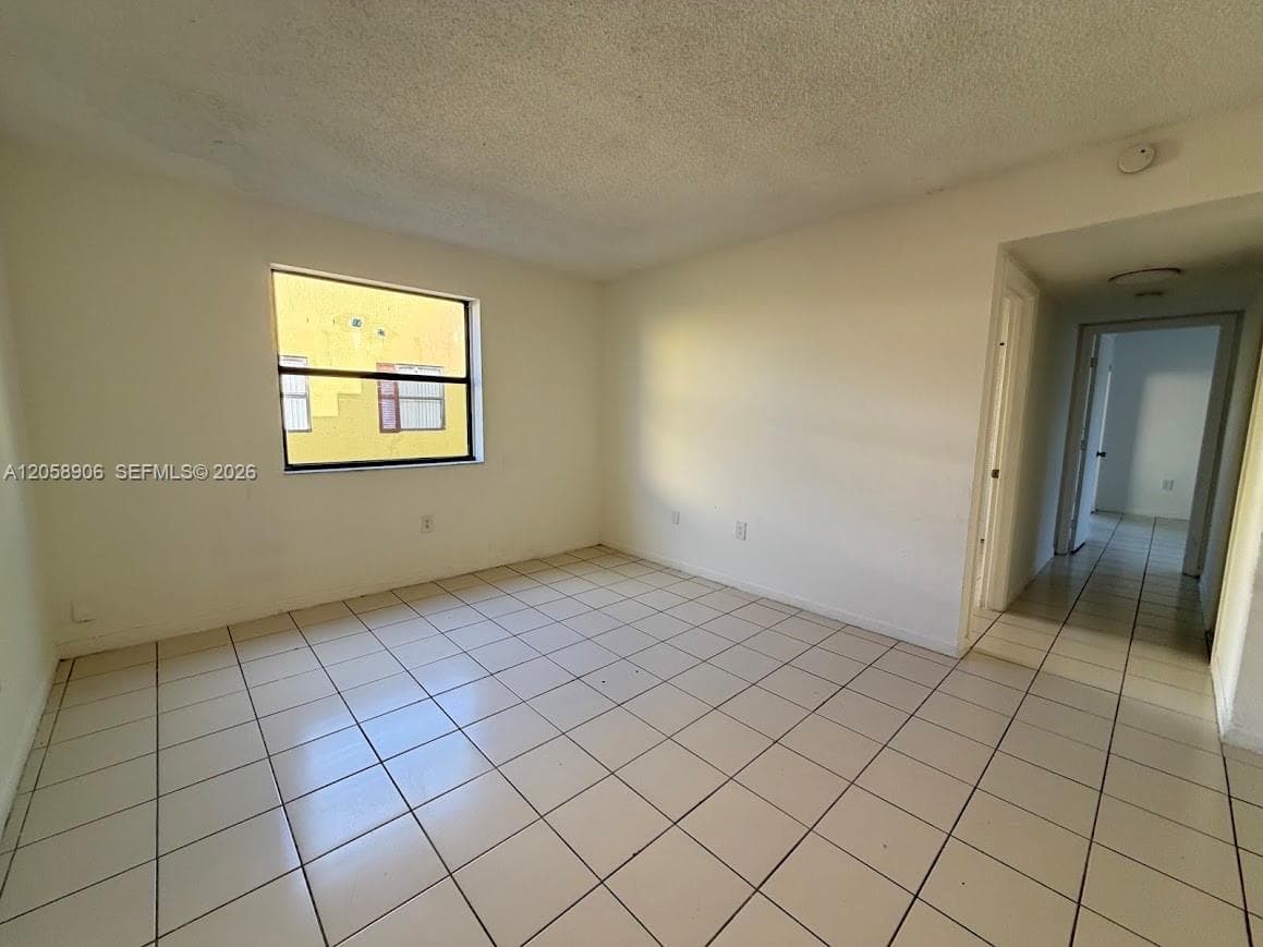 Ceramic tile flooring, neutral wall finishes, and a single-pane window
