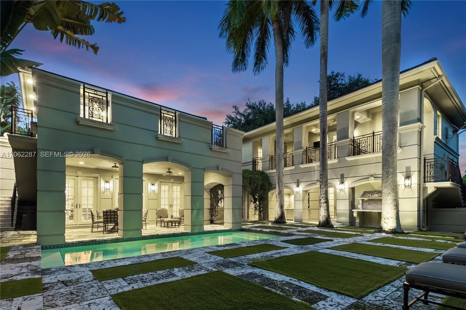 Exterior featuring a pool with stone hardscaping, recessed covered loggias, two-story balconies with ornate metal railings, and a built-in outdoor grill station