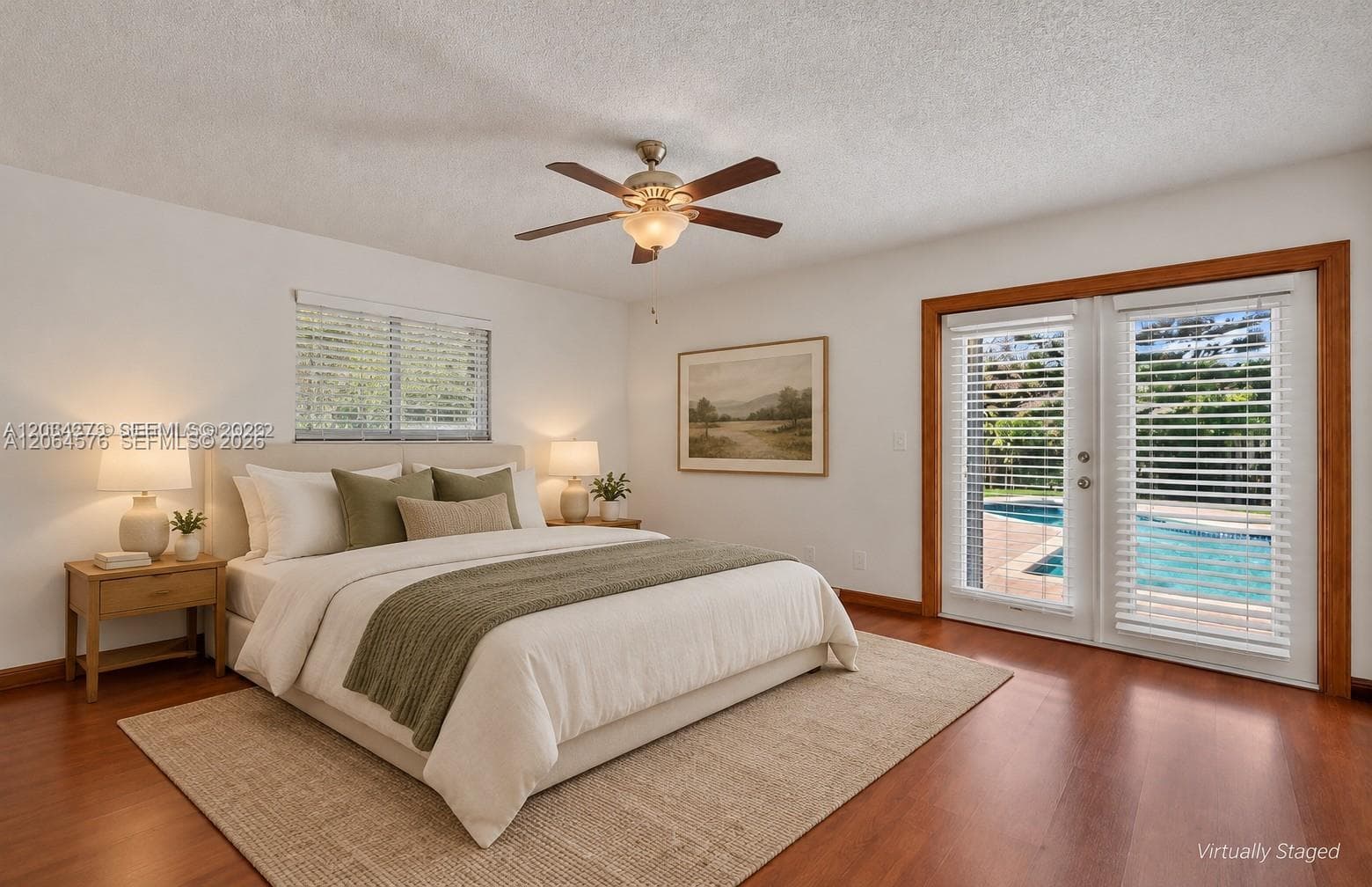 Wood-finish flooring, ceiling fan with integrated lighting, and glass-paneled double doors featuring wood trim and horizontal blinds