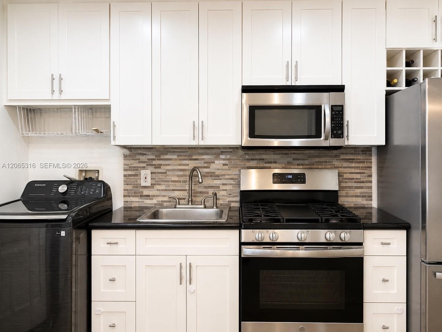 Additional kitchen view highlighting the quartz countertops, cabinetry, and appliances.
