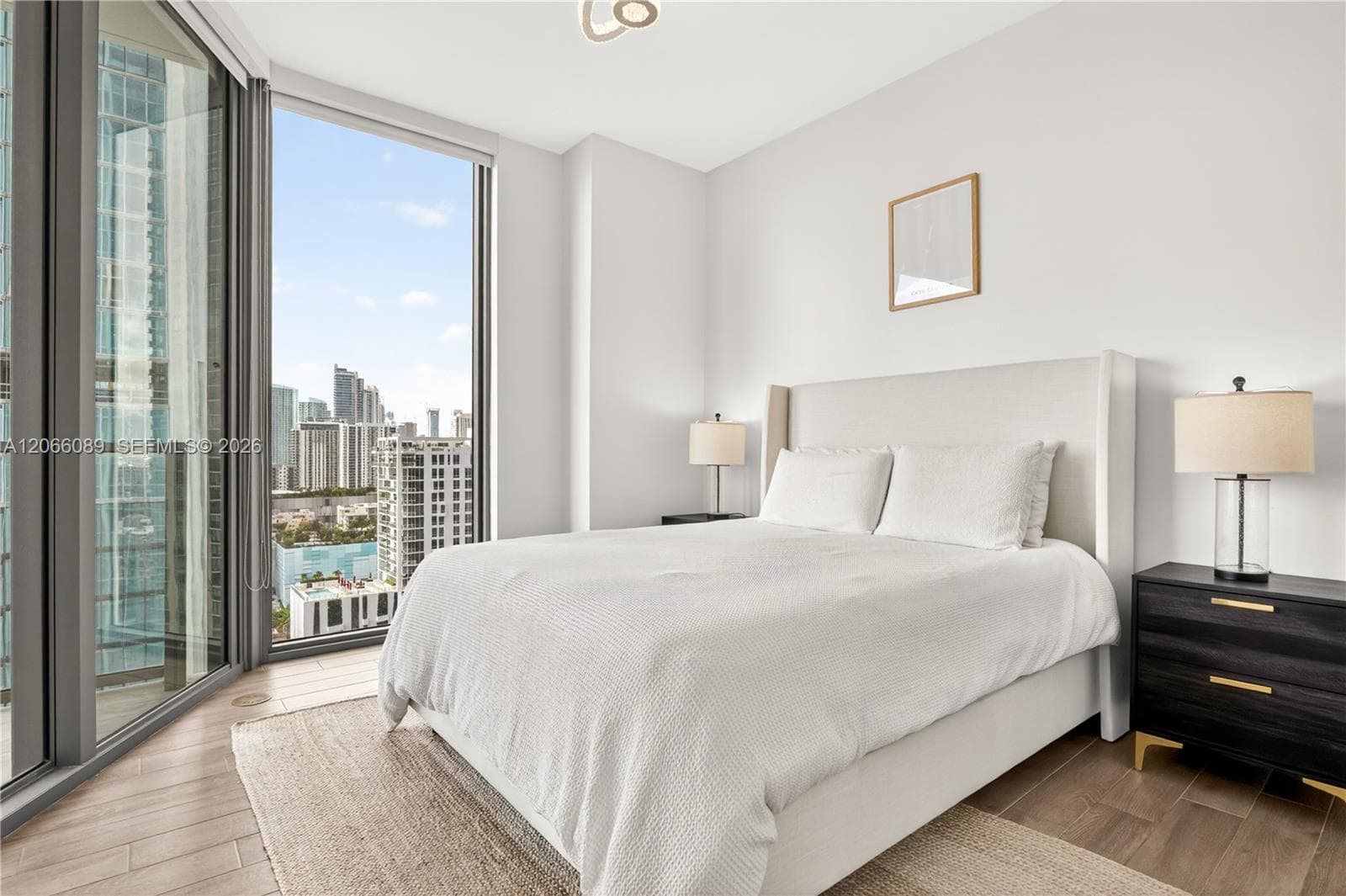 Primary bedroom with floor the ceiling windows overlooking the water