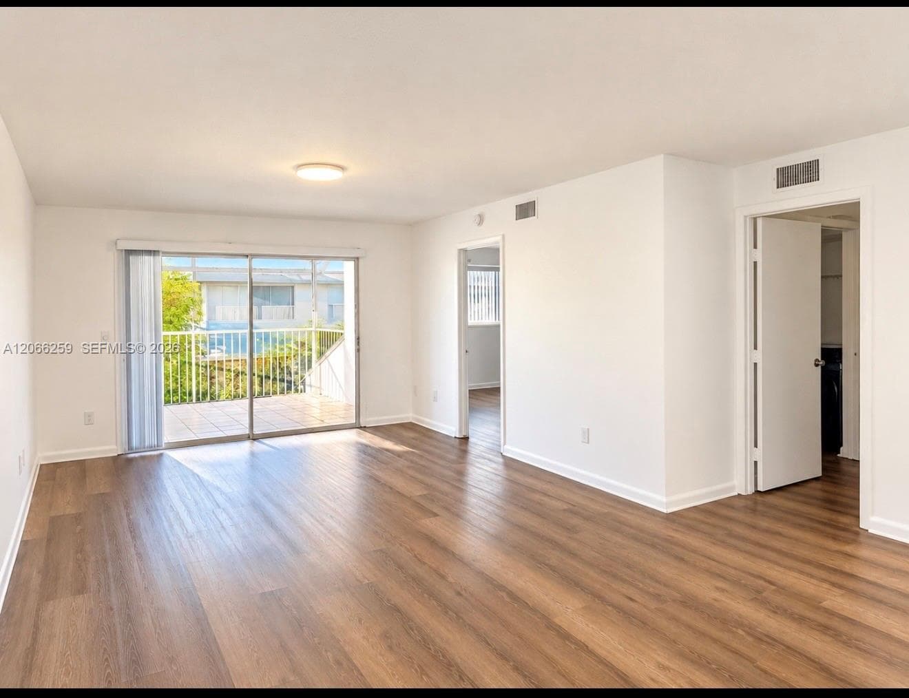 Interior space featuring wood-finish flooring, sliding glass door, and a private balcony