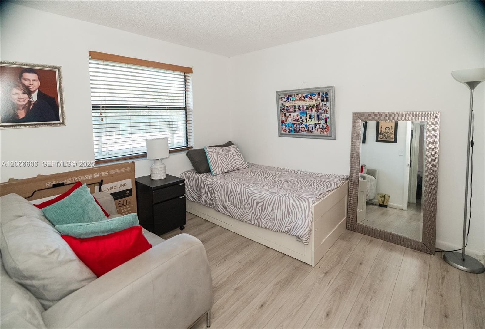 Neutral wall tones, wood-finish flooring, and a window featuring horizontal blinds
