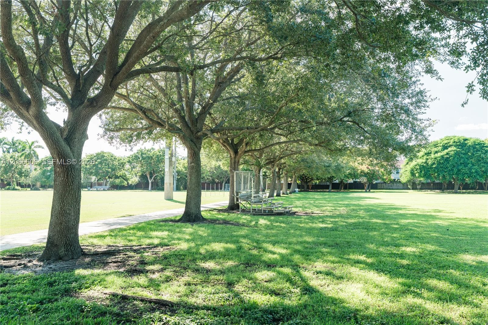 Expansive grounds featuring mature shade trees, a manicured lawn, and a paved walkway
