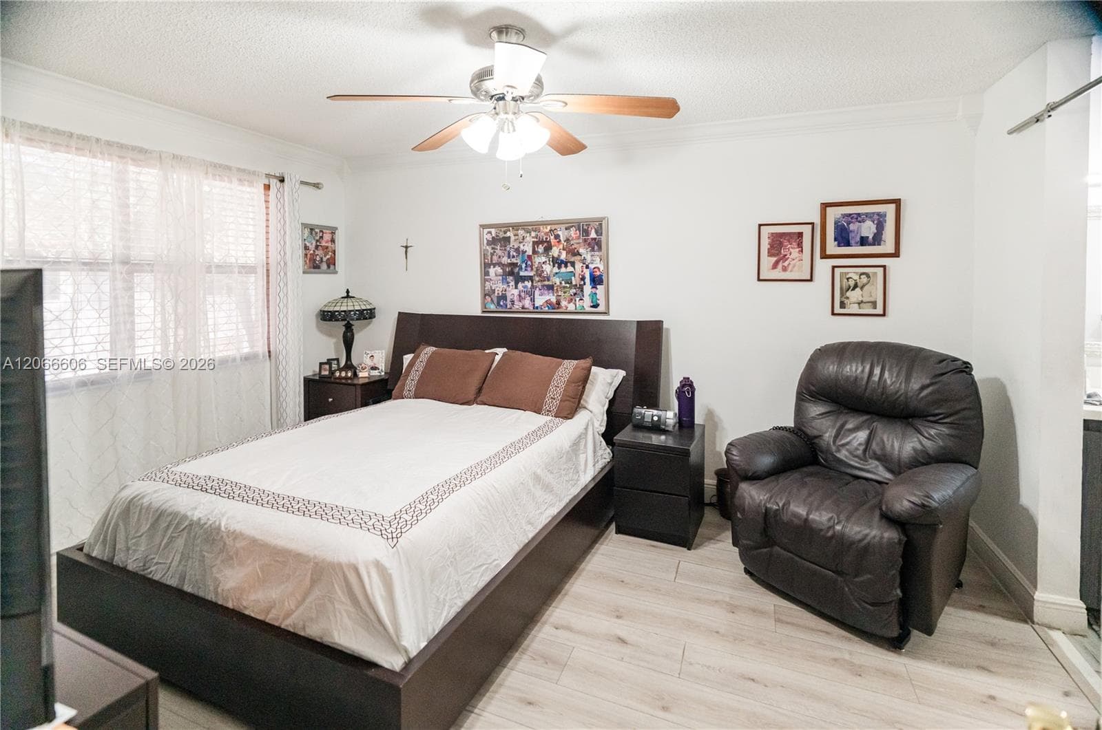 Wood-finish flooring, neutral wall palette, and integrated ceiling fan with multi-point lighting