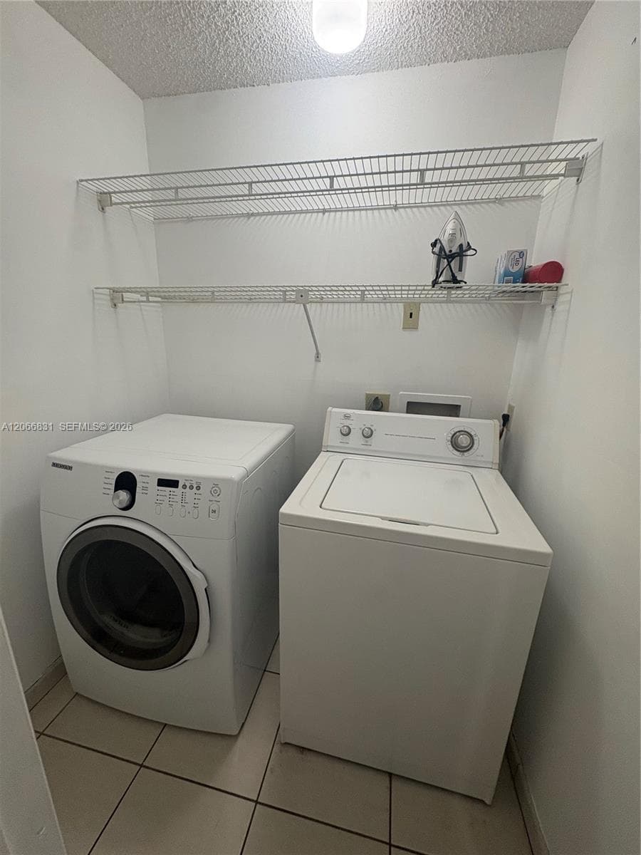 Utility area featuring tile flooring and two tiers of wall-mounted wire shelving