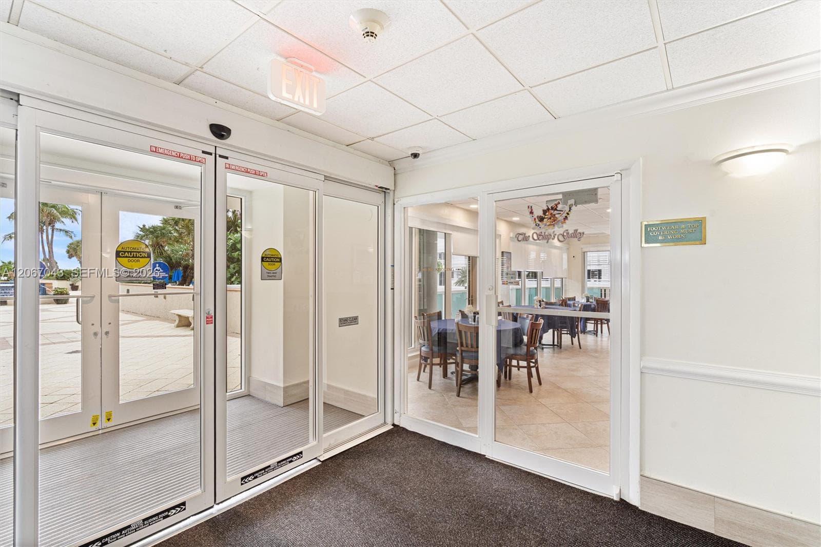 Commercial-grade automatic sliding glass doors, neutral tile flooring, and integrated wall lighting